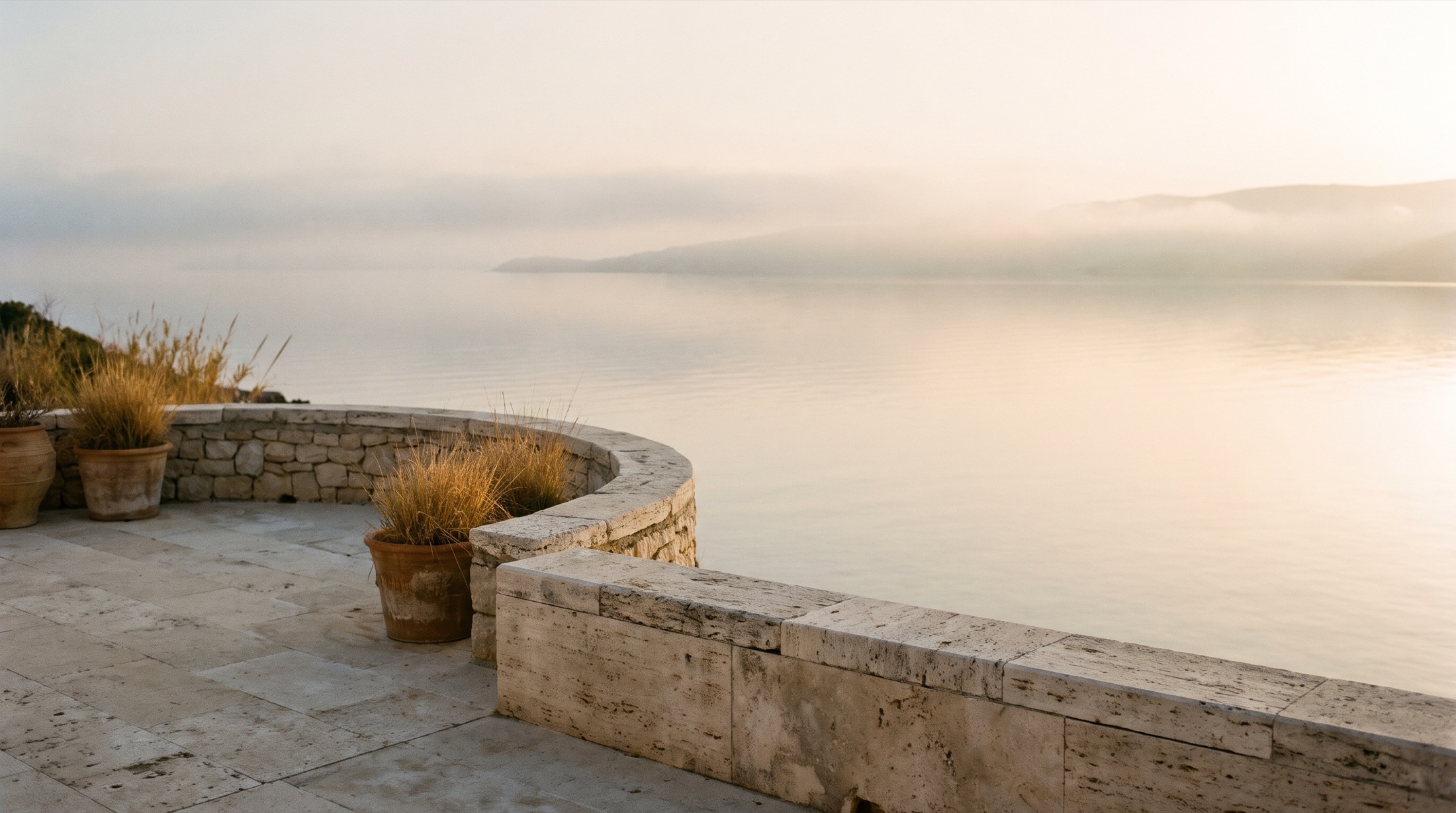 Mar en calma al amanecer desde una terraza de piedra